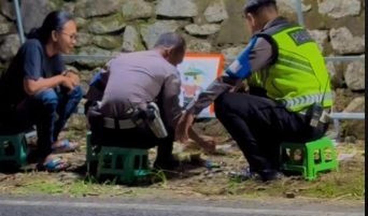 Lucunya, alih-alih berjaga, dua anggota polisi itu justru asik mewarnai gambar di pinggir jalan.