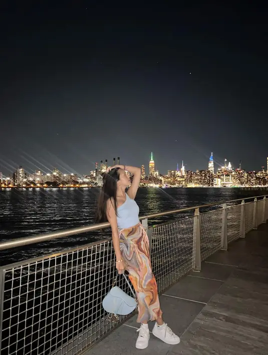 Di sini Beby Tsabina tampil cantik dengan asymmetrical crop top putih. Ia padukan dengan long skirt bercorak abstrak, sneakers putih, dan menenteng tas Dior. Foto: Instagram.