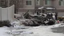 Petugas pemadam kebakaran dan penyelidik melihat puing-puing dari pesawat pribadi yang jatuh di kawasan perumahan Roy, Utah, Amerika Serikat, Rabu (15/1/2020). Pesawat menabrak atap rumah sebelum akhirnya menghantam tanah dan terbakar. (Ben Dorger/Standard-Examiner, via AP)