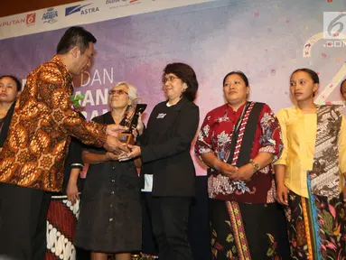 Ketua AJI Suwarjono memberikan penghargaan Tasrif Award kepada Suciwati, istri mendiang aktivis HAM Munir Said Thalib pada perayaan Ulang Tahun Aliansi Jurnalis Independen (AJI) Indonesia, di Jakarta, Senin (07/08). (Liputan6.com/Angga Yuniar)