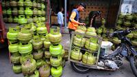 Pekerja menata tabung gas elpiji 3 kg ke atas sepeda motor untuk didistribusikan di kawasan Jakarta, Rabu (4/1/2023). Tahun 2023, pembelian elpiji 3 kg akan diperketat dengan menggunakan KTP. (Liputan6.com/Angga Yuniar)