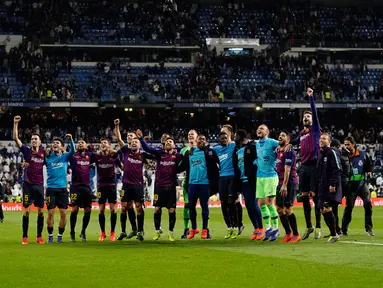 Para pemain Barcelona merayakan kemenangan timnya usai pertandingan melawan Real Madrid pada lanjutan La Liga Spanyol di stadion Santiago Bernabeu, Madrid (2/3). Barcelona menang tipis atas Real Madrid 1-0. (AP Photo/Andrea Comas)