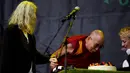 Musisi, Patti Smith (kiri) menyaksikan Dalai Lama meniup kue ulang tahun saat acara Glastonbury Festival, Inggirs, (28/6/2015). (REUTERS/Dylan Martinez)