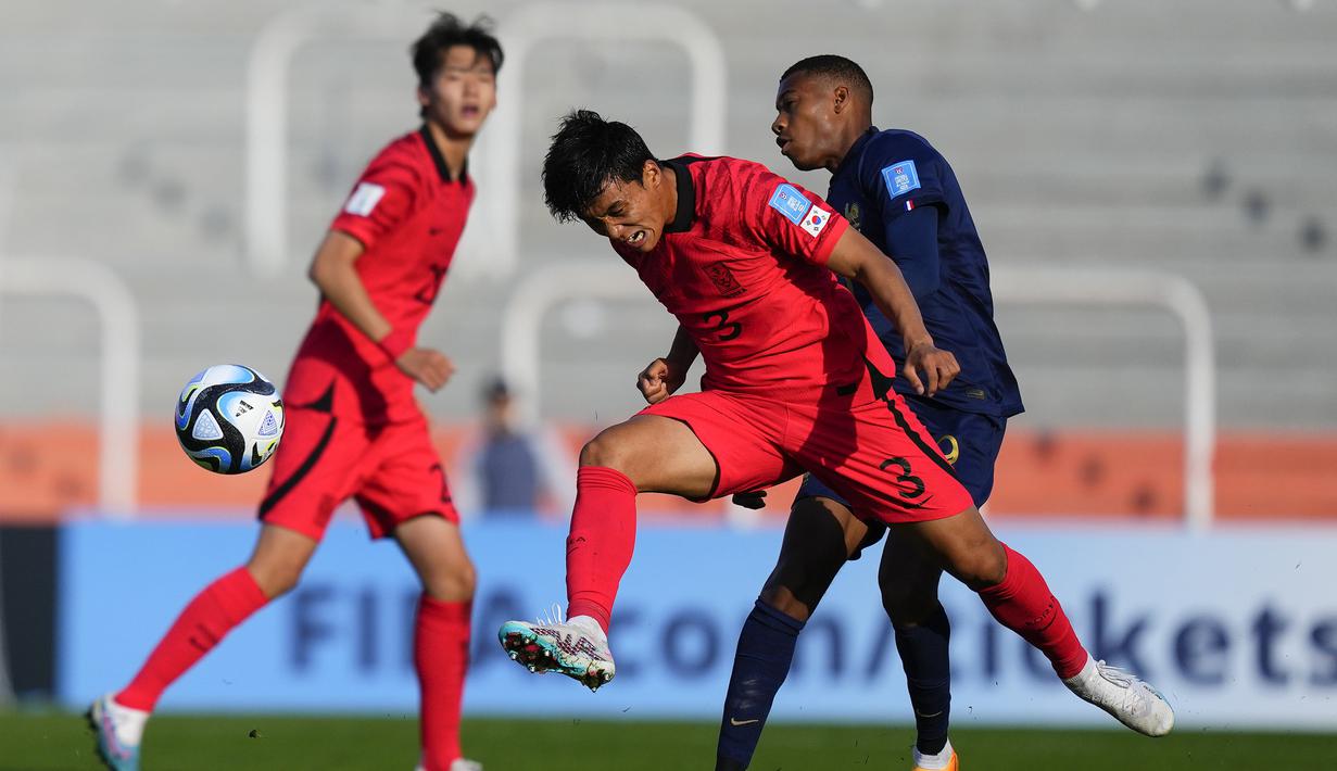 Bek Timnas Korea Selatan U-20, Hwang In-taek (depan) berusaha menghalau bola dari ancaman striker Timnas Prancis U-20, Malamine Efekele pada laga Grup F Piala Dunia U-20 2023 di Malvinas Argentinas Stadium, Mendoza, Argentina, Selasa (23/5/2023) dini hari WIB. (AP Photo/Natacha Pisarenko)