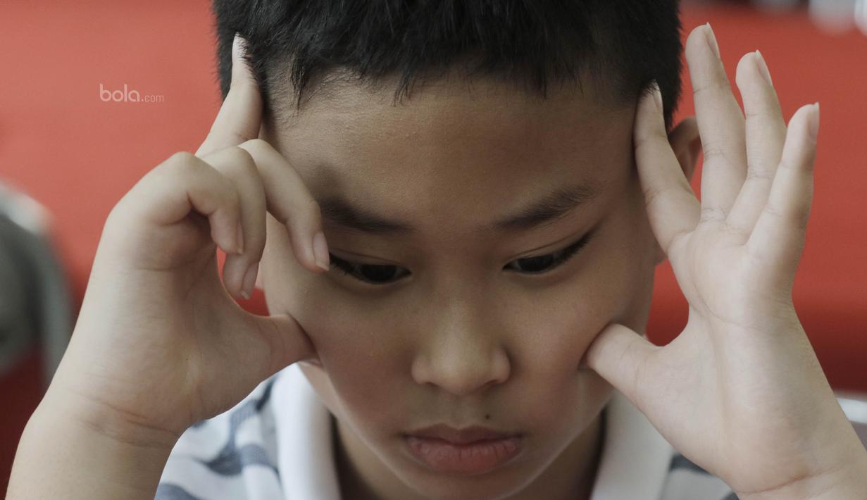 Ekspresi Seorang pecatur cilik saat mengikuti kejuaraan catur daerah tingkat provinsi DKI Jakarta. Kejuaraan ini berhadiah total Rp. 20 juta. (Bola.com/M Iqbal Ichsan)