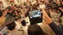  Presiden Jokowi diserbu oleh sejumlah wartawan untuk dimintai tandatangan di ponsel milik mereka usai berbuka puasa di Istana Negara, Jakarta, Senin (6/7/2015). Para wartawan tak menyiakan kesempatan langka tersebut. (Liputan6.com/Faizal Fanani)