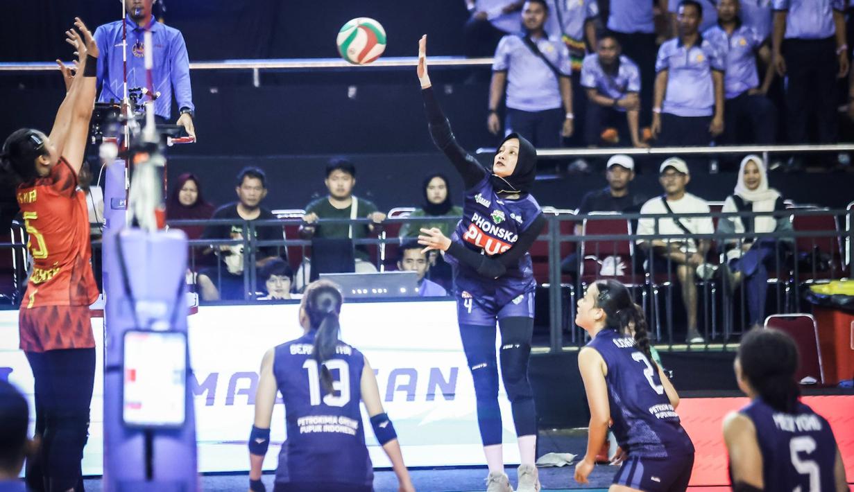 Pemain Petrokimia Gresik Pupuk Indonesia mencoba melakukan spike ke daerah TNI AU Electric pada Final Four Livoli Divisi Utama 2025 yang bertempat di GOR Ki Mageti, Magetan Rabu (15/10/2025).