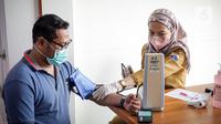 Warga menjalani pemeriksaan kesehatan saat vaksinasi COVID-19 dari Pfizer di Puskesmas Lebak Bulus, Jakarta, Senin (23/8/2021). Dosis vaksin COVID-19 Pfizer akan diutamakan untuk warga yang belum pernah menerima suntikan vaksin. (Liputan6.com/Faizal Fanani)
