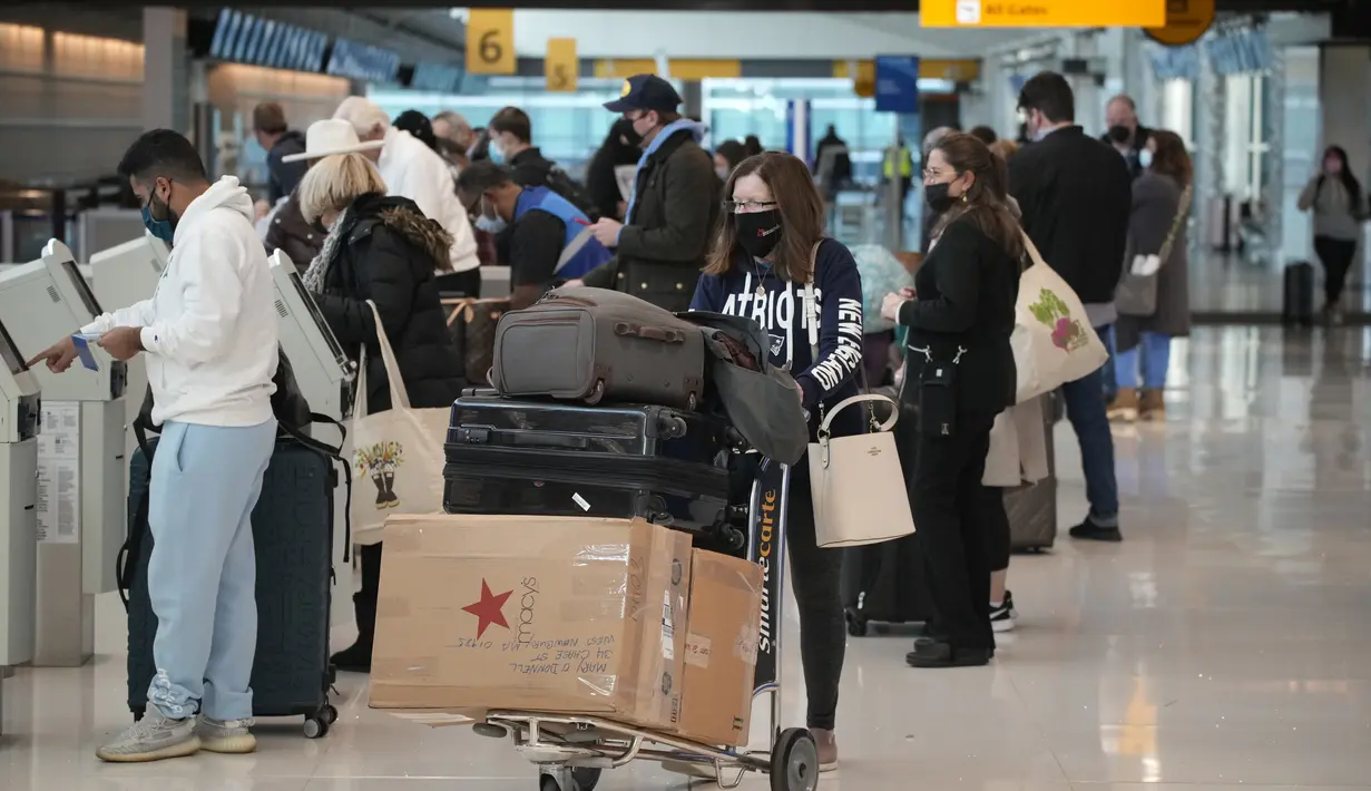 Wisatawan mengantre di kios check-in United American Airlines di terminal Bandara Internasional Denver di Denver (26/12/2021). Maskapai menunda ratusan penerbangan pada Minggu (26/12), karena alasan keterbatasan petugas terkait Covid-19 menambah masalah perjalanan usai Natal. (AP Photo/David Zalubow