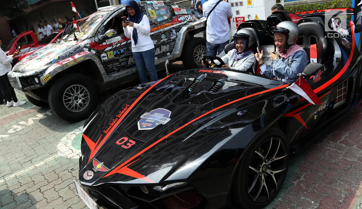 Dua wanita berfoto di dalam mobil listrik ITS yang mengikuti kegiatan Jambore Kendaraan Listrik Nasional di Kantor PLN UID Jakarta, Selasa (3/9/2019). Jambore nasional tersebut berbentuk rally dan menempuh jarak 900 kilometer (km) dari Surabaya menuju Jakarta. (Liputan6.com/Johan Tallo)