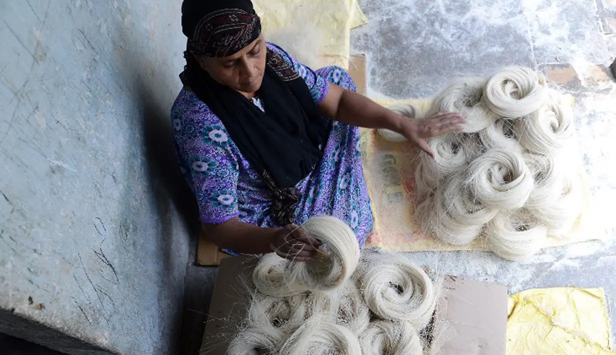 Pekerja menggulung Seviiyan (sejenis bihun), bahan dasar pembuatan sheerkhorma, di Hyderabad, India, 23 Juni 2015. Sheerkhorma merupakan hidangan manis tradisional khas Ramadan bagi muslim India. (AFP PHOTO/NOAH Seelam)