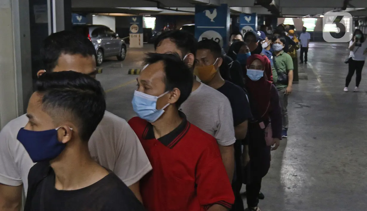 Pedagang saat antre untuk menjalani vaksinasi COVID-19 di Pasar Tanah Abang Blok A, Jakarta, Rabu (17/2/2021). Total sasaran vaksinasi tahap kedua ini mencapai 38.513.446 yang terdiri dari 21 juta lebih lansia, dan hampir 17 juta untuk pekerja pelayanan publik. (Liputan6.com/Herman Zakharia)