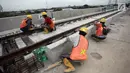 Pekerja merapikan bantalan rel di Depo LRT, Kelapa Gading, Jakarta Utara, Kamis (25/1). Satu gerbong kereta LRT mampu menampung 135 orang. (Liputan6.com/Arya Manggala)