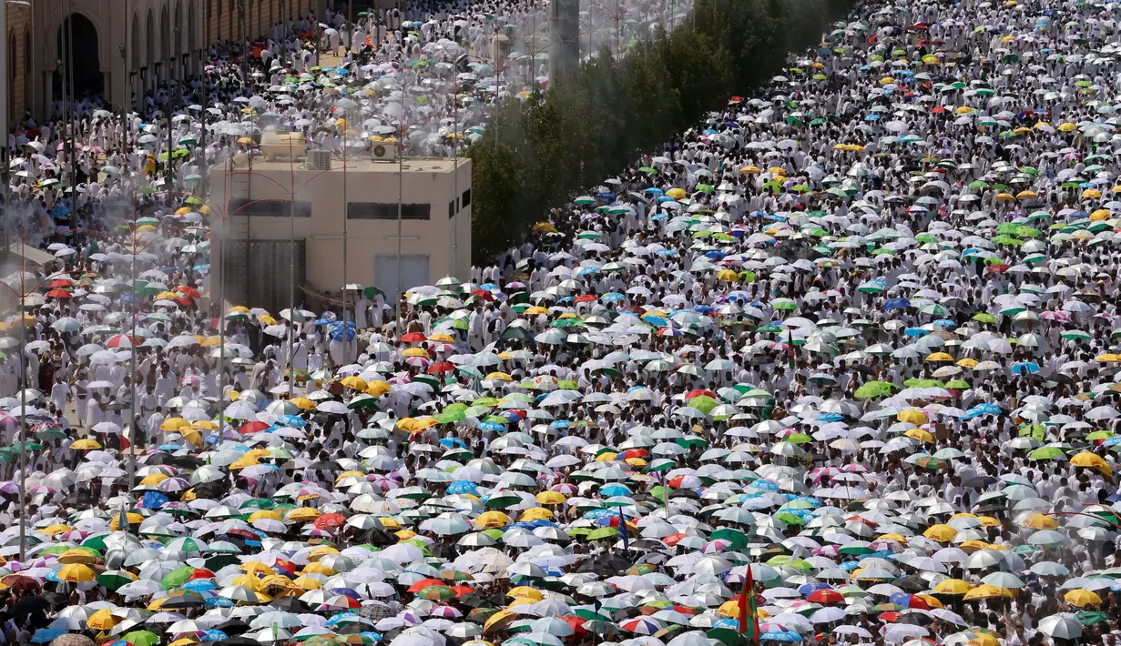 Jutaan jemaah haji berjalan kaki meninggalkan Masjid Namira, Padang Arafah usai melaksanakan salat dekat kota suci Mekkah (11/09). Mereka berjalan kaki dari Mina menuju padang Arafah sejauh 14 km dan singgah di Masjid Namira. (REUTERS/Ahmed Jadallah)