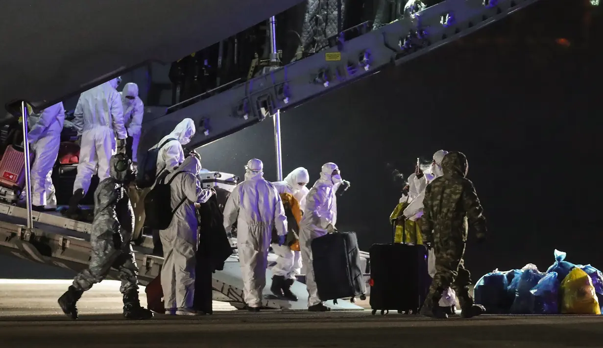 Penumpang mengambil barang bawaan mereka saat turun dari pesawat kargo di Bandara Etimesgut, Ankara, Turki, Sabtu (1/2/2020). Turki memulangkan warganya dari Wuhan menyusul wabah virus corona di kota tersebut. (Photo by Adem ALTAN/AFP)
