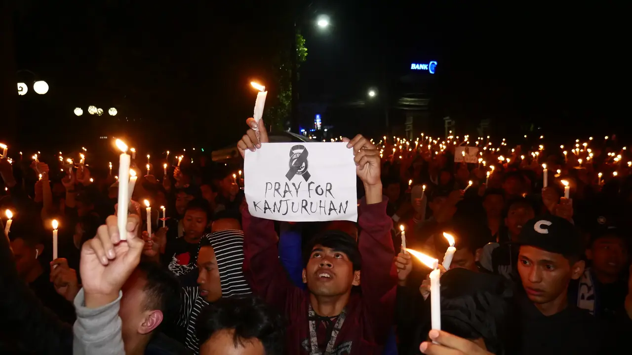 Para suport Nyalakan lilin saat doa bersama untuk korban Tragedi Stadion Kanjuruhan Malang Jawa Timur.