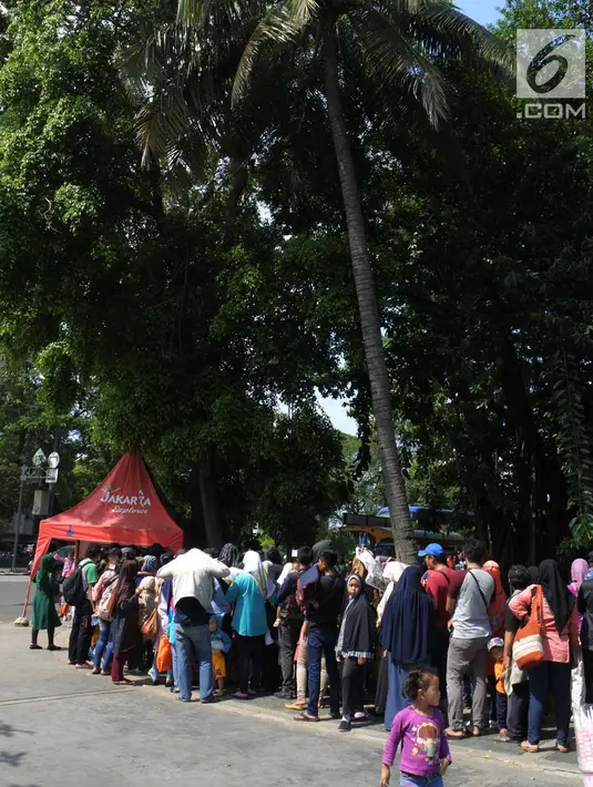 Sejumlah warga antre memasuki bus tingkat City Tour di depan Masjid Istiqlal, Jakarta, Sabtu (31/3). Bus tingkat wisata ini akan berkeliling melewati tempat-tempat khas yang menjadi simbol Kota Jakarta. (Merdeka.com/Imam Buhori)