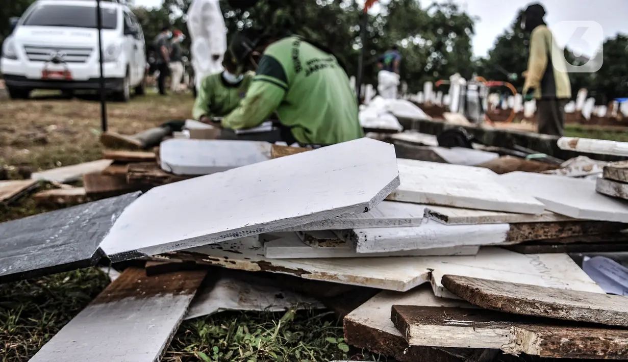 Petugas menyelesaikan pembuatan papan nisan di TPU Bambu Apus, Jakarta, Kamis (28/1/2021). Pemprov DKI menyiapkan 6 lokasi baru untuk pemakaman jenazah pasien Covid-19 dengan total kapasitas 17.900 petak makam, salah satunya TPU Bambu Apus 2 dan TPU Srengseng Sawah 2. (merdeka.com/Iqbal S Nugroho)