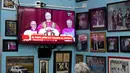 Ia juga menjabat di Komisi Kepausan untuk Amerika Latin, sebuah kawasan yang menjadi rumah bagi hampir 40 persen umat Katolik di seluruh dunia. Tampak dalam foto, Paus Leo XIV diproyeksikan pada sebuah TV saat orang-orang duduk di sebuah restoran di Buenos Aires pada 8 Mei 2025. (Luis ROBAYO/AFP)