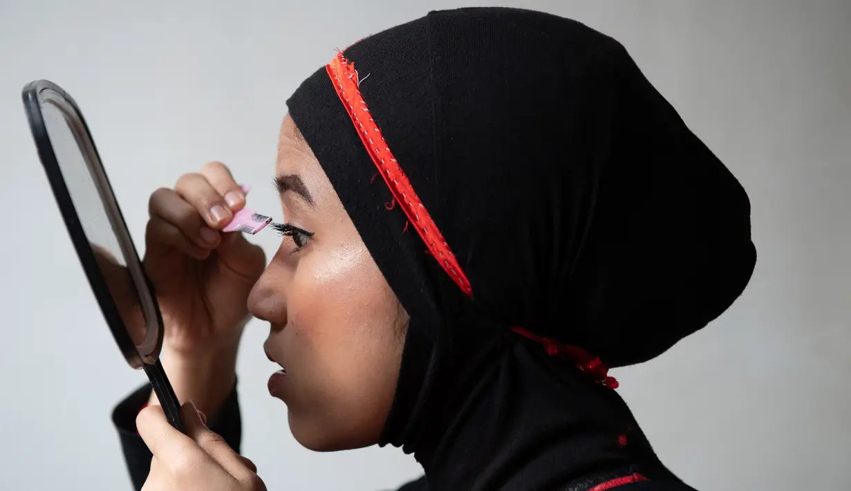 Pegulat hijab Malaysia, Nor "Phoenix" Diana bersolek sebelum mengikuti pertandingan yang diselenggarakan Malaysia Pro Wrestling di Kuala Lumpur, 6 Juli 2019. Pada awal kompetisi, Nor Diana mengenakan penutup wajah atau topeng untuk mengurangi kemungkinan orang bisa mengenalinya. (Mohd RASFAN/AFP)