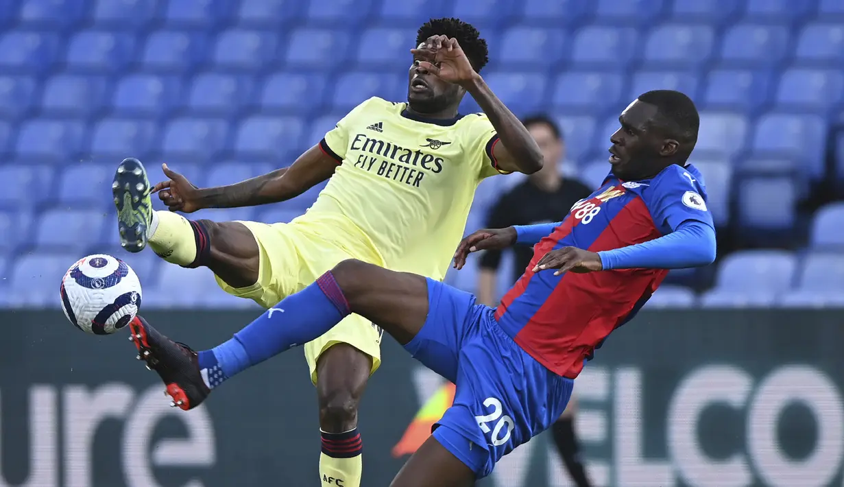 Striker Crystal Palace, Christian Benteke (kanan) berbebut bola dengan gelandang Arsenal, Thomas Partey dalam laga lanjutan Liga Inggris 2020/2021 pekan ke-37 di Selhurst Park, London, Rabu (19/5/2021). Crystal Palace kalah 1-3 dari Arsenal. (AP/Facundo Arrizabalaga/Pool)