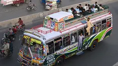 Sebuah bus dengan penumpang di atas atap berjalan di sepanjang jalan di Lahore pada 19 April 2023, saat orang-orang menuju kampung halaman mereka untuk merayakan Hari Raya Idul Fitri, yang menandai berakhirnya bulan puasa Ramadhan. (Photo by Arif Ali / AFP)