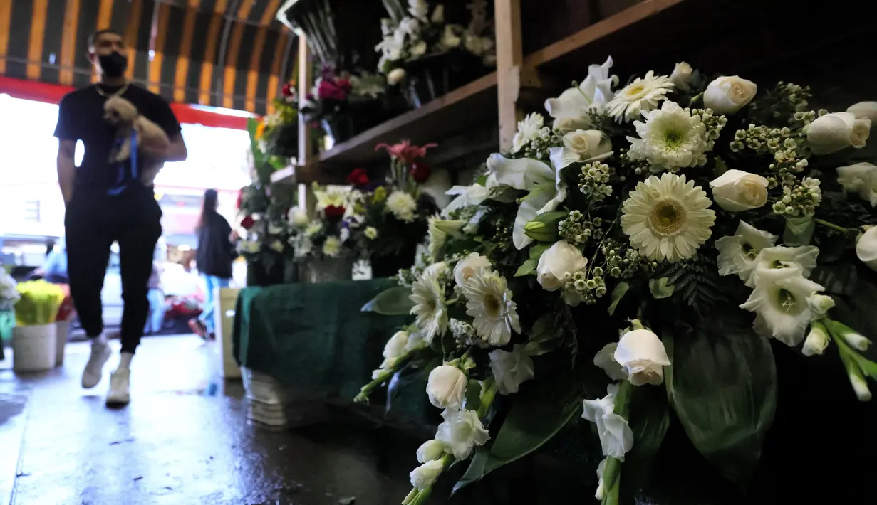 Seorang pria melihat-lihat bunga sebelum Hari Valentine di tengah pandemi COVID-19 di distrik bunga  di Los Angeles, California (12/2/2021). Toko bunga di daerah tersebut sibuk tahun ini dengan pemesanan bunga Hari Valentine dan karangan bunga pemakaman COVID-19. (Mario Tama/Getty Images/AFP)