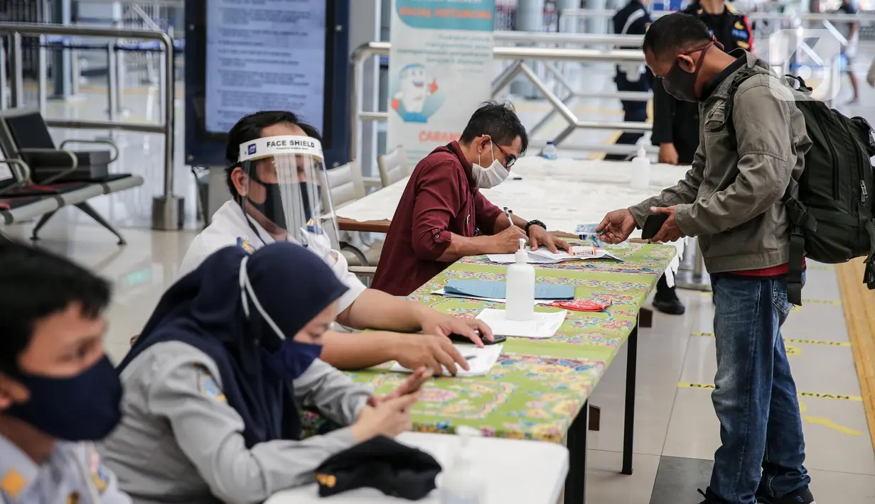 Calon penumpang melapor kepada petugas di Stasiun Pasar Senen, Jakarta, Jumat (10/7/2020). PT KAI telah mengoperasikan lima perjalanan kereta jarak jauh untuk tujuan Bandung, Cirebon, dan Surabaya mulai Jumat 10 Juli 2020. (Liputan6.com/Faizal Fanani)