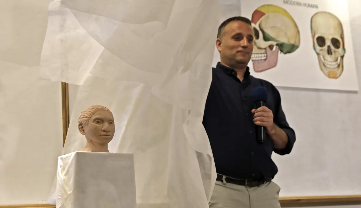 Liran Carmel menunjukkan model cetak 3D wajah gadis spesies manusia prasejarah Denisovan di Universitas Ibrani di Yerusalem (19/9/2019). Para ilmuwan berkat teknologi modern telah mampu menciptakan kembali wajah Denisovan dengan akurasi 85 persen. (AFP Photo/Menahem Kahana)