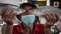 Pedagang menunjukan ikan bandeng di Pasar Petak Sembilan, Glodok, Jakarta, Senin (31/1/2022). Ikan bandeng banyak dibeli jelang Imlek sebagai hidangan saat perayaan Tahun Baru masyarakat Tionghoa itu. (Liputan6.com/Faizal Fanani)