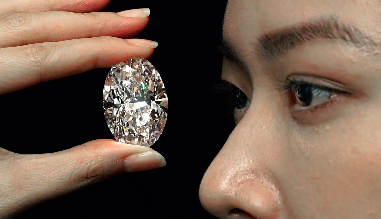 Sebuah berlian putih 102,39 karat, yang dikenal sebagai warna D, tanpa cela dipamerkan model di ruang lelang Sotheby di Hong Kong, Senin (28/9/2020).  Berlian itu diperkirakan akan terjual dengan harga 12 juta dolar AS (Rp 180 miliar) hingga 30 juta dolar AS (Rp 450 miliar). (AP Photo/Vincent Yu)