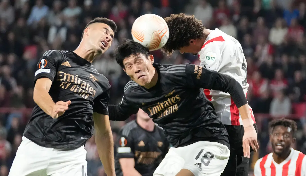 Pemain Arsenal Takehiro Tomiyasu (tengah) dan Gabriel Martinelli berebut bola udara dengan pemain PSV Eindhoven Andre Ramalho pada pertandingan sepak bola Grup A Liga Europa di Stadion Philips, Eindhoven, Belanda, 27 Oktober 2022. Arsenal kalah 0-2 dari PSV Eindhoven. (AP Photo/Peter Dejong)