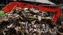 Alat berat beroperasi mengangkut sampah yang menumpuk di Pintu Air Manggarai, Jakarta, Selasa (4/12). Tingginya intensitas hujan di wilayah Jabodetabek membuat sampah yang terbawa arus sungai menumpuk di Pintu Air Manggarai. (Liputan6.com/Faizal Fanani)