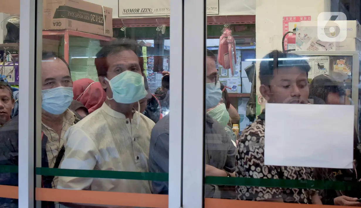Warga mengantre untuk membeli masker di Jak Mart milik PD Pasar Jaya di  Pasar Pramuka, Jakarta Timur, Jumat (6/3/2020). PD Pasar Jaya melakukan operasi pasar sejak Kamis (5/3/2020) kemarin untuk menjaga ketersediaan dan membuat harga masker kembali terjangkau. (Liputan6.com/Faizal Fanani)