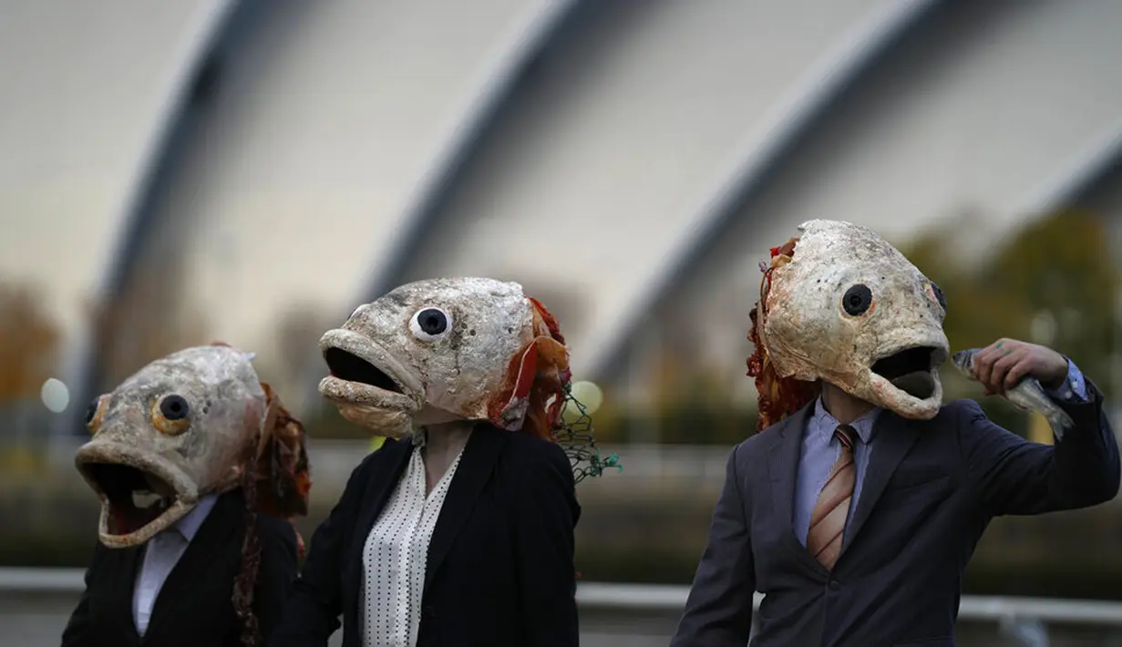 Juru kampanye dari kelompok lingkungan Ocean Rebellion mengenakan topeng kepala ikan saat aksi protes terhadap Marine Stewardship Council (MSC) di Glasgow, Skotlandia, 4 November 2021. Aksi ini dilakukan di sela-sela KTT Iklim PBB COP26 yang sedang berlangsung. (AP Photo/Alastair Grant)