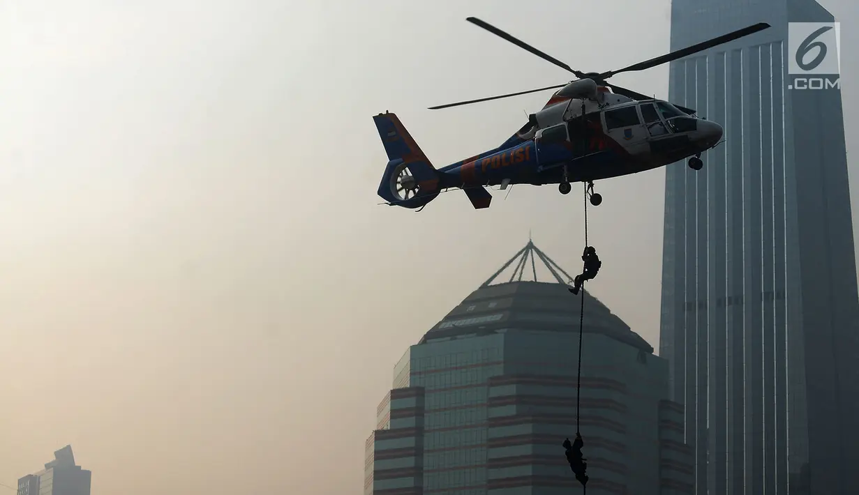 Petugas kepolisian menuruni helikopter menggunakan tali dalam apel pengamanan Asian Games 2018 di Lapangan Ditlantas Polda Metro Jaya, Jakarta, Selasa (31/7). (Merdeka.com/Imam Buhori)