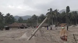 Warga berjalan di daerah yang terkena dampak letusan Gunung Semeru di Lumajang, Jawa Timur, Indonesia, Minggu (5/12/2021). Gunung Semeru di Jawa Timur kembali meletus pada Sabtu (4/12/2021) pada pukul 15.00 WIB. (AP Photo/Rokhmad)