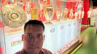 Bola.com berfoto di depan enam trofi juara yang diraih Bayern Munchen pada 2020. Saat itu Bayern menjadi juara Bundesliga, DFB Pokal, DFL Supercup, Liga Champions, Piala Super Eropa, dan Piala Dunia Antarklub. (Bola.com/Benediktus Gerendo Pradigdo)