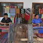 Perajin menenun kain songket menggunakan peralatan tradisional di sentral kerajinan songket Patuh, Desa Sukarara, Lombok Tengah, Selasa (13/10). Desa Sukarara menjadi salah satu penghasil kain tenun khas suku Sasak, Lombok. (Liputan6.com/Gempur M Surya)