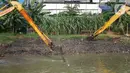 Alat berat mengeruk sampah bercampur lumpur di aliran Banjir Kanal Barat, Jakarta, Rabu (14/10/2020). Pengerukan serta pembersihan waduk, sungai, dan saluran air dari lumpur juga sampah untuk mencegah pendangkalan serta mengantisipasi banjir saat musim hujan. (Liputan6.com/Immanuel Antonius)