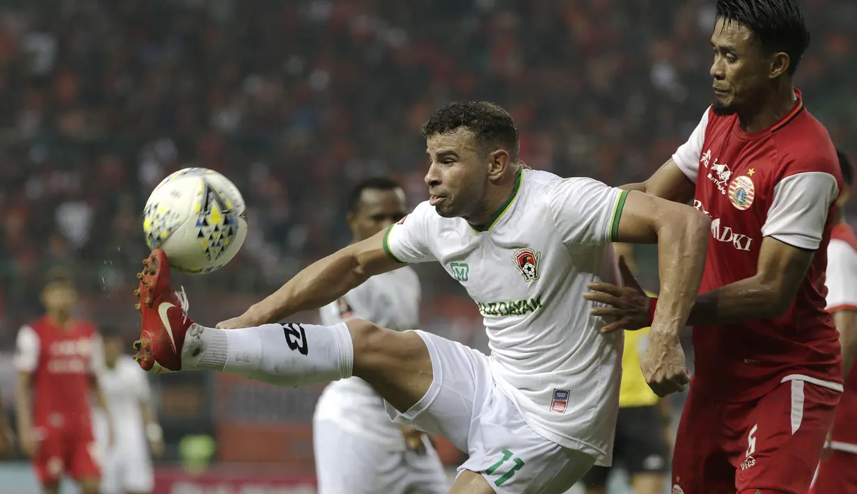 Striker Kalteng Putra, Diogo Campos, berusaha melewati bek Persija Jakarta, Maman Abdurrahman, pada laga perempat final Piala Presiden 2019 di Stadion Patriot, Bekasi, Kamis (28/3). Persija kalah adu penalti dari Kalteng. (Bola.com/Yoppy Renato)