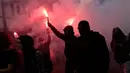 Para pengunjuk rasa memegang suar saat demonstrasi di Nantes, Prancis, 18 Oktober 2022. Industri di seluruh Prancis melakukan mogok massal untuk mendorong kenaikan upah yang mengikuti kenaikan inflasi. (AP Photo/Jeremias Gonzalez)