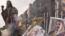 Dukun Peru melakukan ritual ramalan untuk prediksi tahun 2022 sebelum Malam Tahun Baru di samping poster Presiden Andres Manuel Lopez Obrador (kiri) dan Nicolas Maduro dari Venezuela, di bukit San Cristobal di Lima, Peru (29/12/2021). (AFP/Ernesto Benavides)