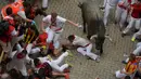 Peserta terjatuh saat menghindari serudukan banteng dalam festival San Fermin di Pamplona, Spanyol utara, (9/7). Dalam festival ini peserta banyak yang mengalami luka memar terkena tusukkan tanduk banteng. (REUTERS/Susana Vera)