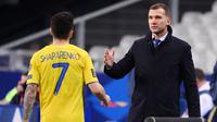 Pelatih Ukraina, Andriy Shevchenko, memberikan selamat kepada anak asuhnya, Mykola Shaparenko, usai melawan Prancis pada laga Kualifikasi Piala Dunia di Stadion Saint Denis, Paris, Kamis (25/3/2021). Kedua tim bermain imbang 1-1. (AFP/Franck Fife)