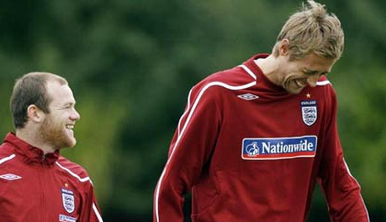 Wayne Rooney and Peter Crouch share a joke as they walk to the training ground for training at London Colney, North London, on October 7, 2008. AFP PHOTO/Glyn Kirk