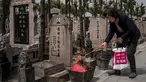 Seorang wanita membakar dupa sebagai persembahan selama festival Qingming di sebuah pemakaman di Shanghai (6/6). Qingming adalah ritual tahunan etnis Tionghoa untuk bersembahyang dan ziarah kubur sesuai dengan ajaran Khong Hu Cu. (AFP/Johannes Eisele)