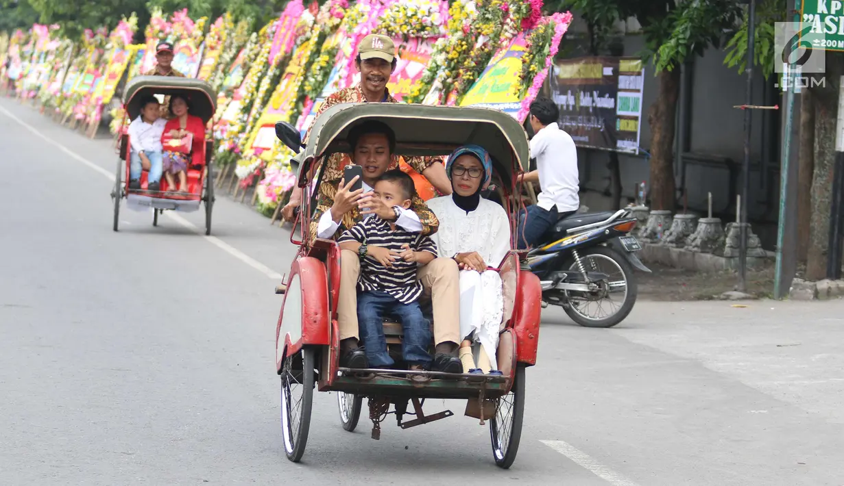 Tamu undangan menggunakan becak menuju Gedung Graha Saba Buana, Solo, Rabu (8/11). Panitia pernikahan Kahiyang-Bobby menyiapkan 50 becak untuk mengantar para tamu tersebut menuju acara resepsi. (Liputan6.com/Angga Yuniar)