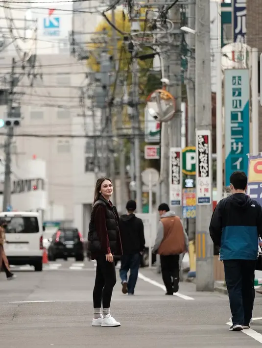 <p>Gaya santai, namun tetap memesona ala Luna Maya saat berada di Jepang. Ia mengenakan kaus bercorak garis hitam-putih, yang dilayer dengan kemeja lengan panjang berwarna wine, ditambah sleeveless puffer jacket hitam. Ia padukan gayanya dengan legging hitam dan sneakers putih. Foto: Instagram.</p>