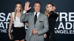 Sylvester Stallone (tengah) bersama dua putrinya, Sistine Stallone (kiri) dan Sophia Stallone melambaikan tangan saat menghadiri Saint Laurent Fall Collection di Los Angeles, California, Rabu (10/2/2016). (Larry Busacca/Getty Images for SAINT LAURENT)
